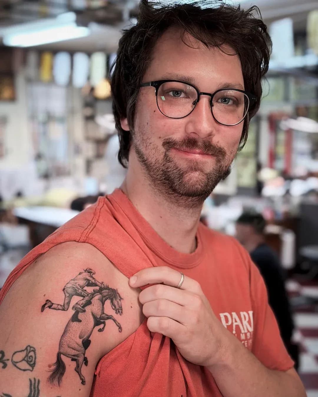 Illustrative tattoo of cowboy and horse on upper arm by Dan Gilsdorf, tattoo artist in Portland, Oregon
