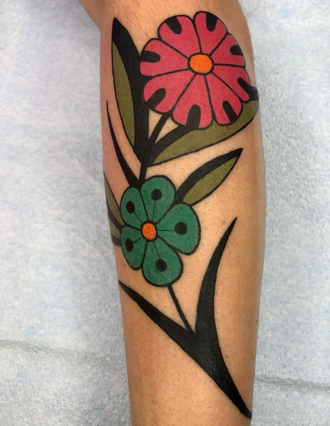 Geometric tattoo of flowers on leg by Derek Yost, tattoo artist in Portland, Oregon