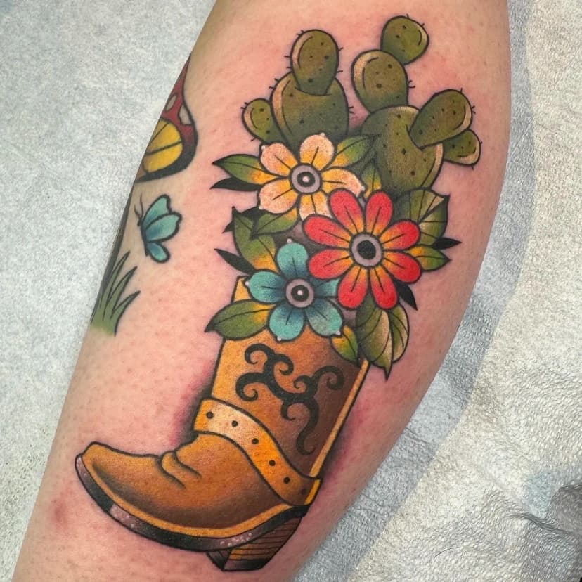 Neo-traditional tattoo of cowboy boot and flowers on forearm by Dev Renee, tattoo artist in Portland, Oregon