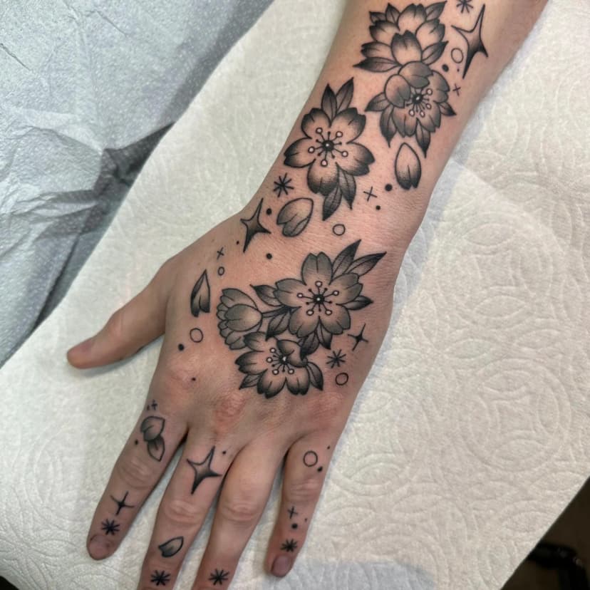 Traditional tattoo of cherry blossoms on hand by Dev Renee, tattoo artist in Portland, Oregon