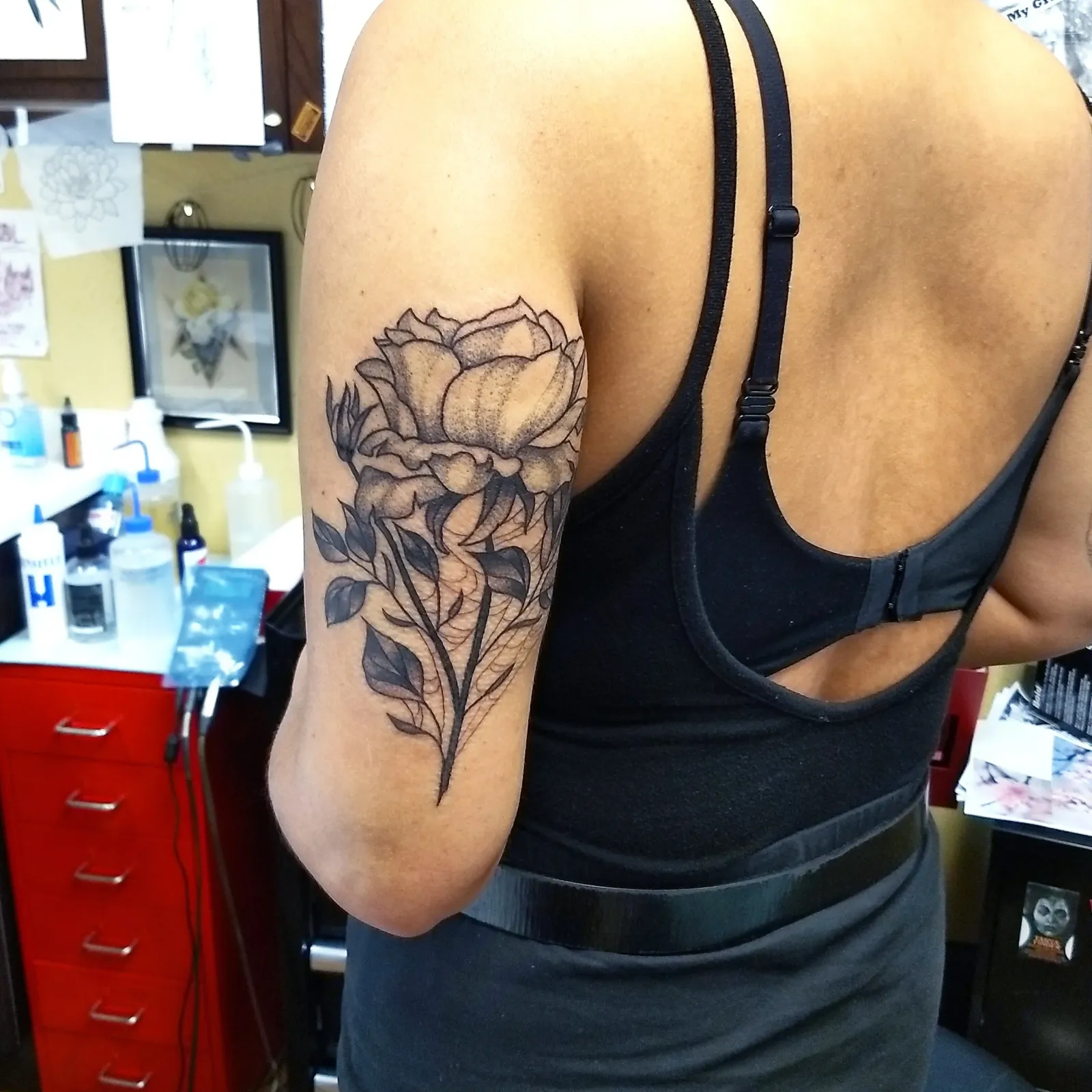 Blackwork tattoo of rose and leaves on upper arm by Elli Adams, tattoo artist in Portland, Oregon