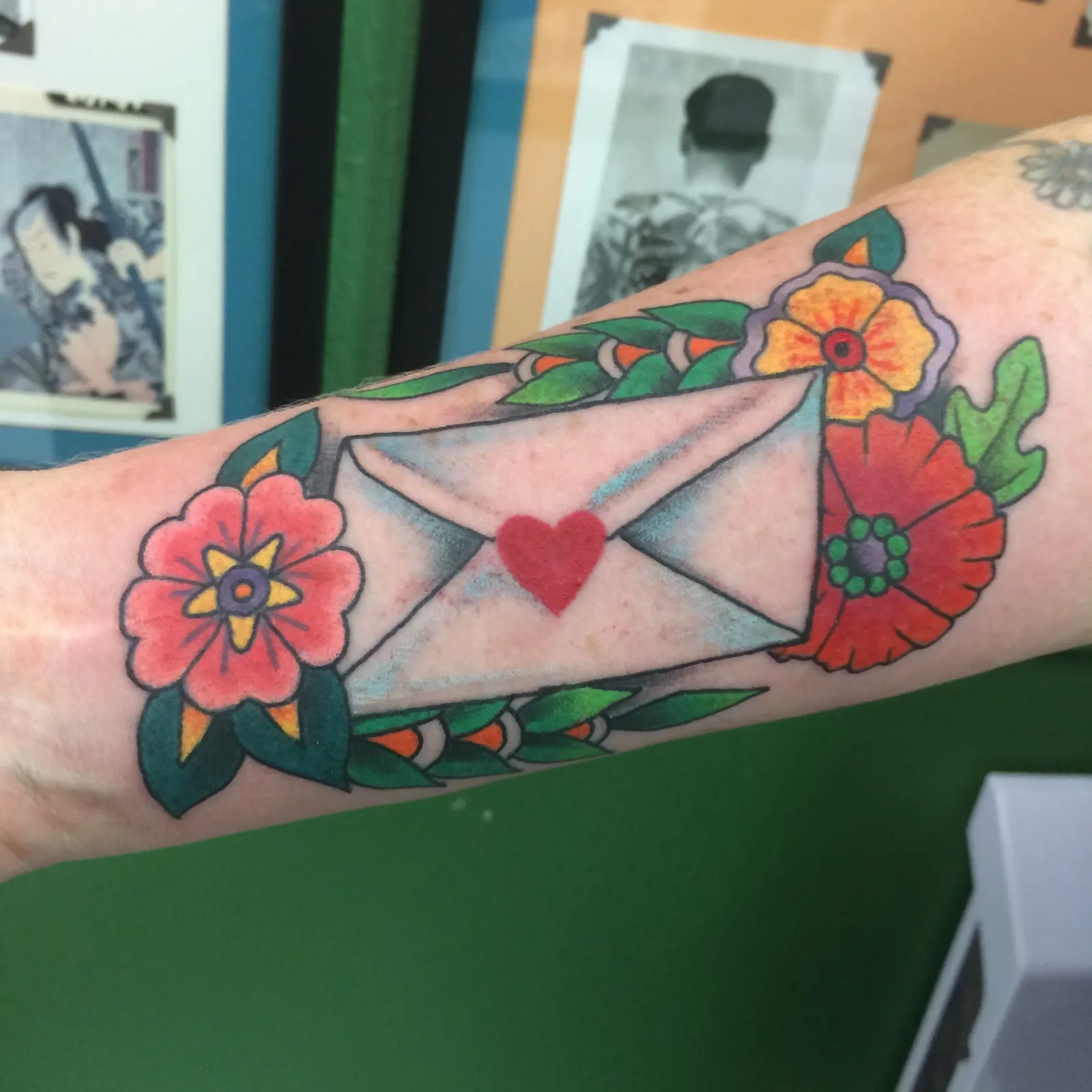 Traditional tattoo of envelope and flowers on forearm by Mav Mess, tattoo artist in Portland, Oregon