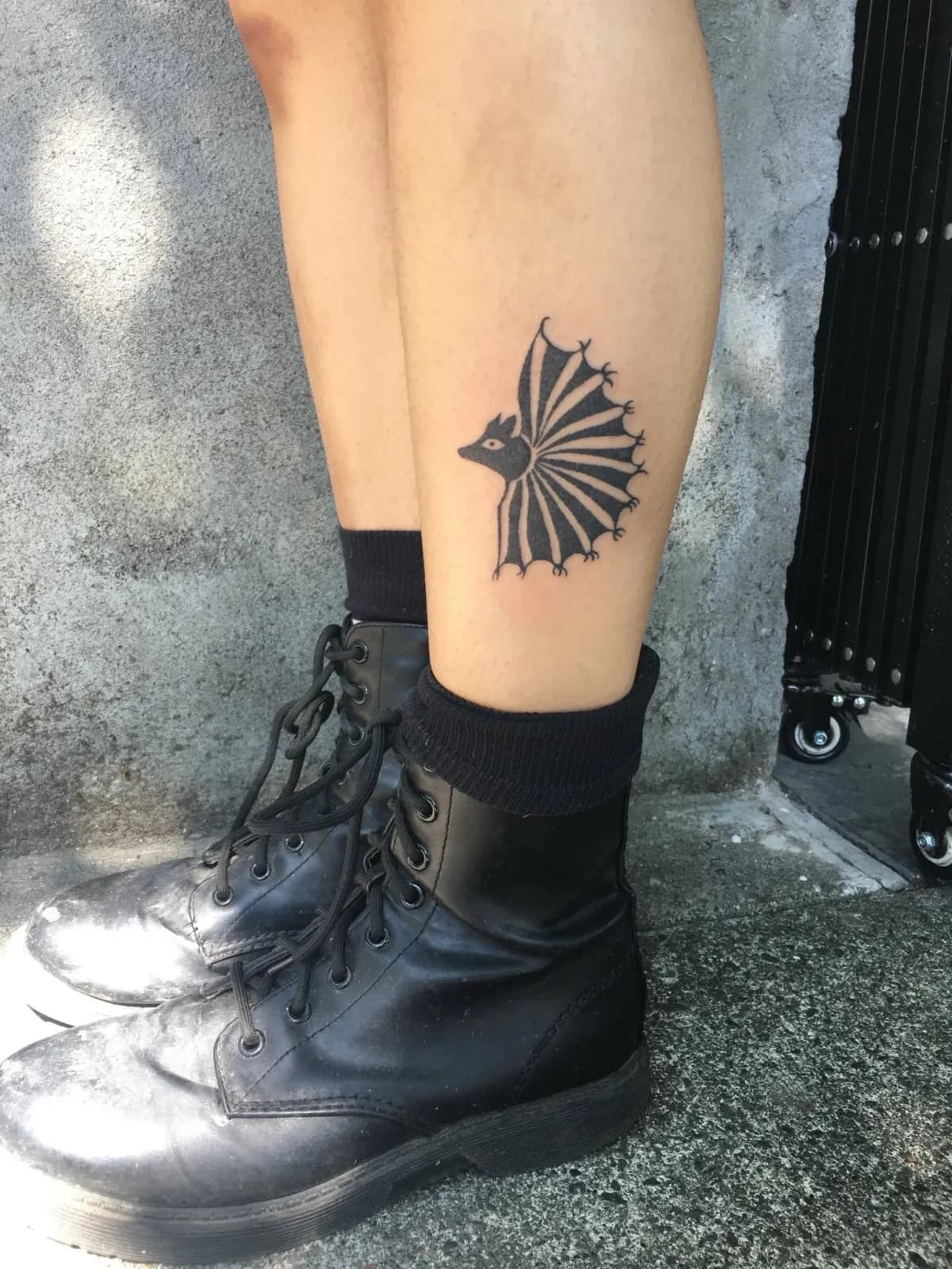 Blackwork tattoo of frilled lizard on calf by Riversteeth, tattoo artist in Portland, Oregon