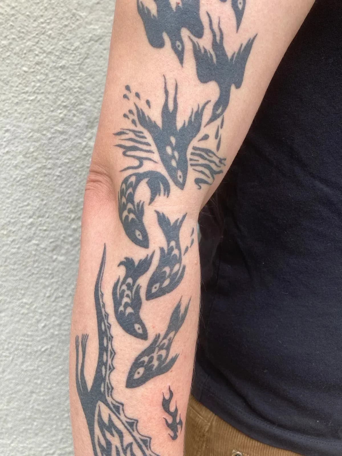 Japanese tattoo of koi fish and water on forearm by Riversteeth, tattoo artist in Portland, Oregon