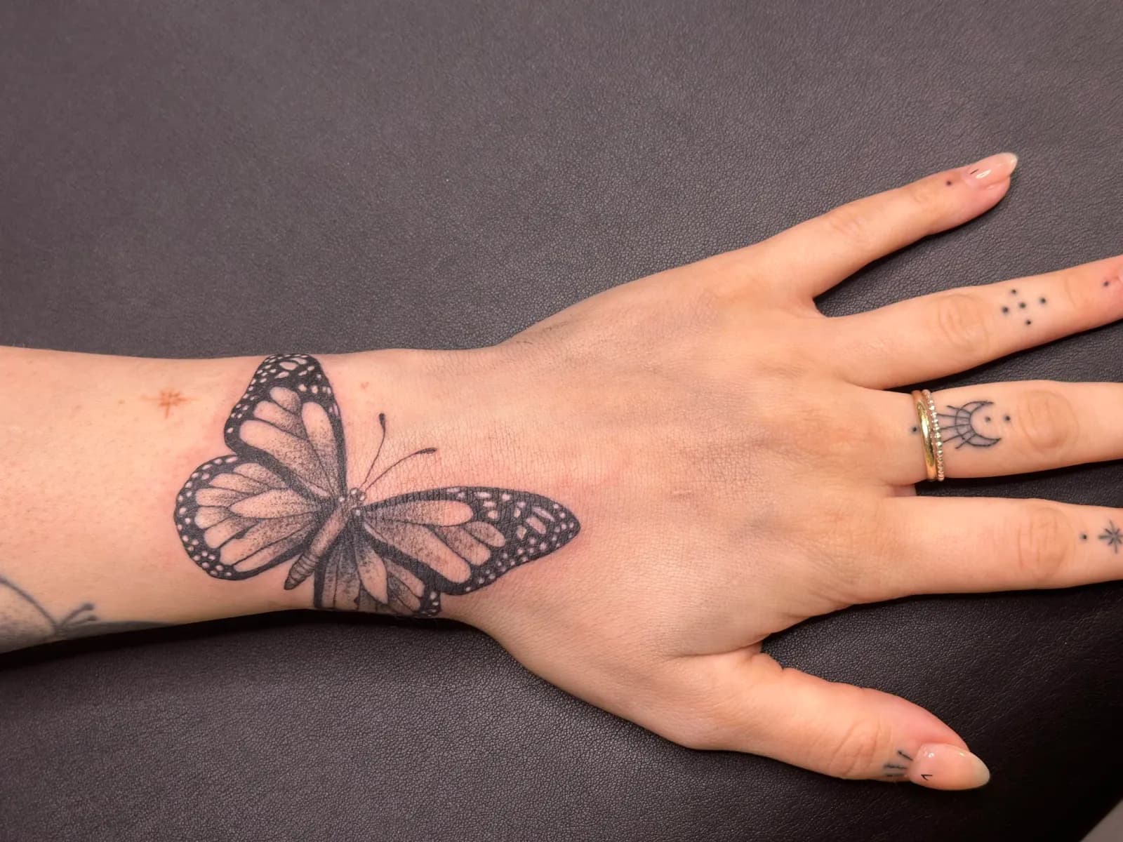 Fine-line tattoo of butterfly on hand by Sadie, tattoo artist in Portland, Oregon