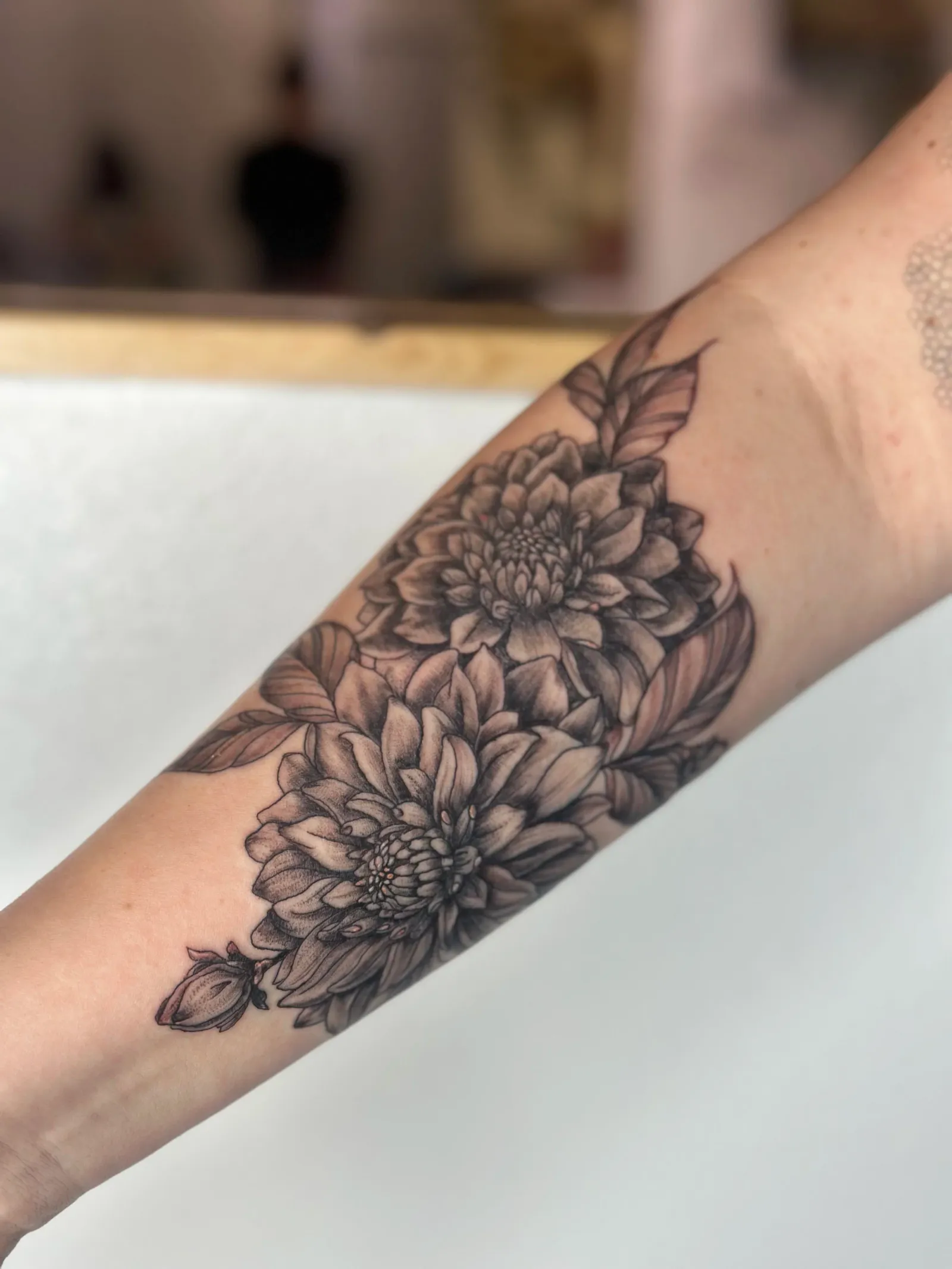 Realism tattoo of dahlia flowers on forearm by Sadie, tattoo artist in Portland, Oregon