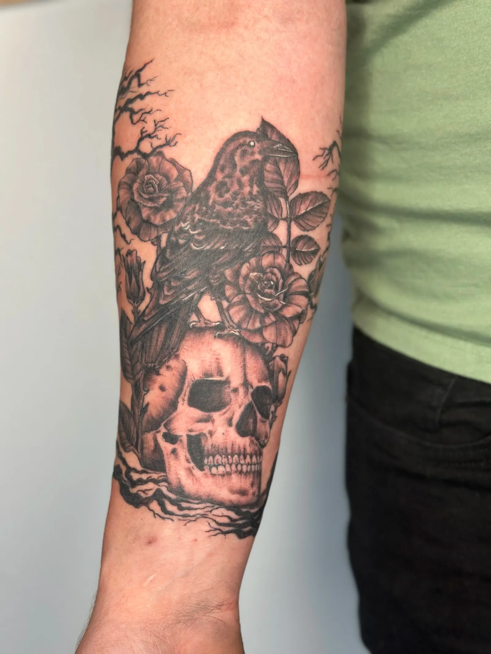Realism tattoo of skull and raven on forearm by Sadie, tattoo artist in Portland, Oregon